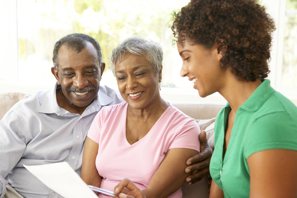 Older couple reviewing health care plans with their adult daughter